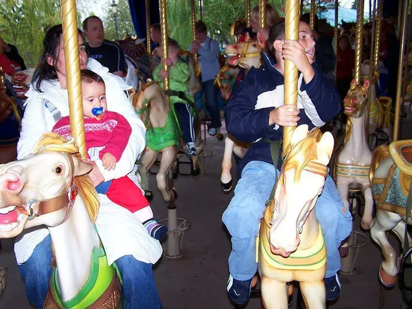 Familia disfrutando del paseo en el tiovivo de Lancelot