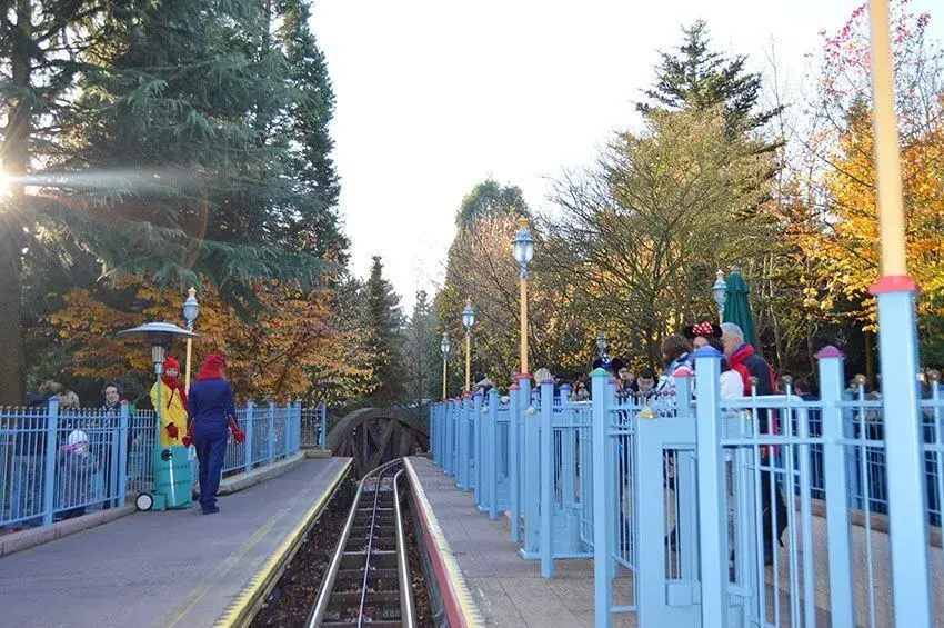 Visitantes caminando junto a los carriles del tren Casey Jr en Disneyland Paris