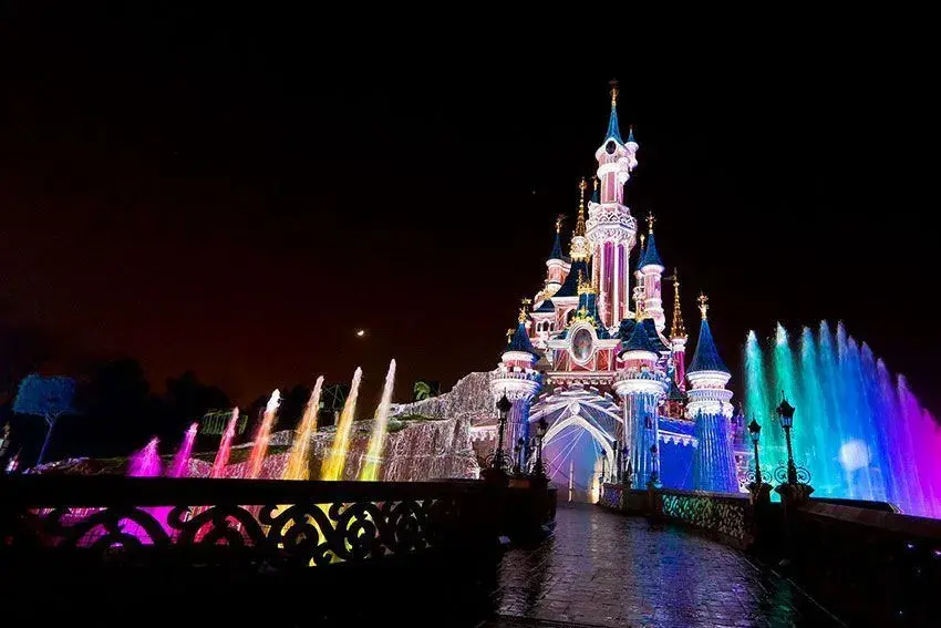 Vista nocturna del Castillo de la Bella Durmiente en Disneyland Paris iluminado