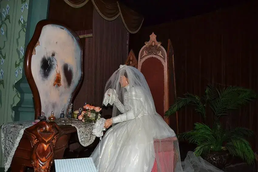 Princesa mirando un espejo donde aparece una calavera - Imagen icónica de la muerte en Phantom Manor