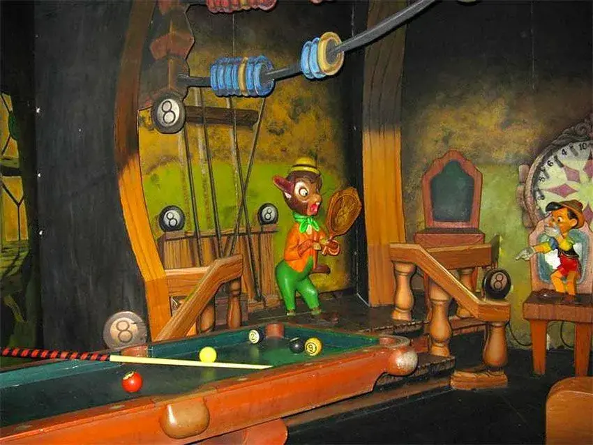 Escena con personajes temáticos y una mesa de billar dentro de la atracción Les Voyages de Pinocchio en Disneyland Paris
