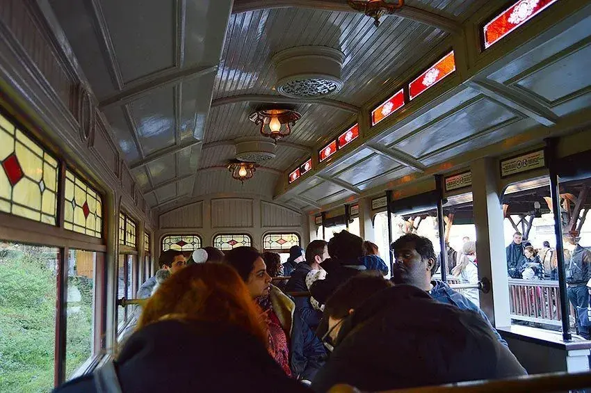 Pasajeros dentro del vagón del tren Disneyland Railroad en Frontierland - Relájate mientras viajas por el parque