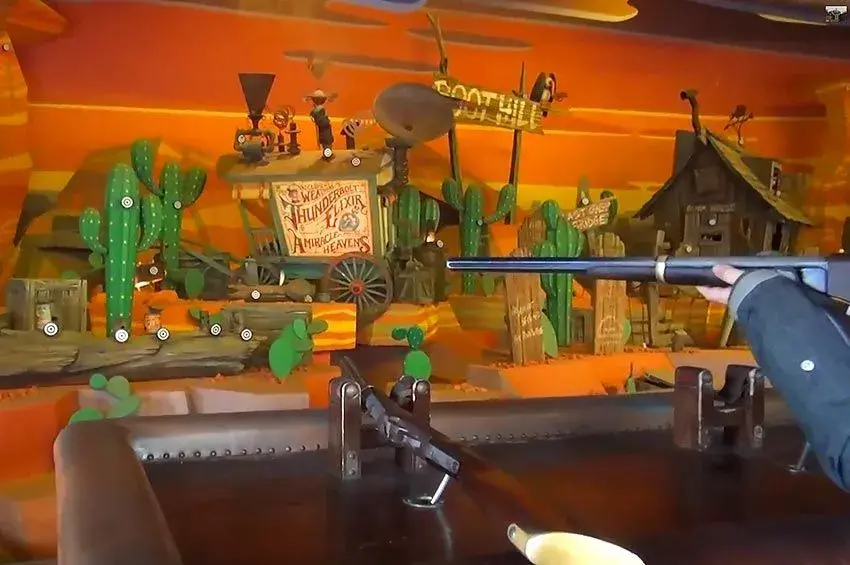 Persona empuñando un rifle durante la atracción Rustler Shootin' en Disneyland París