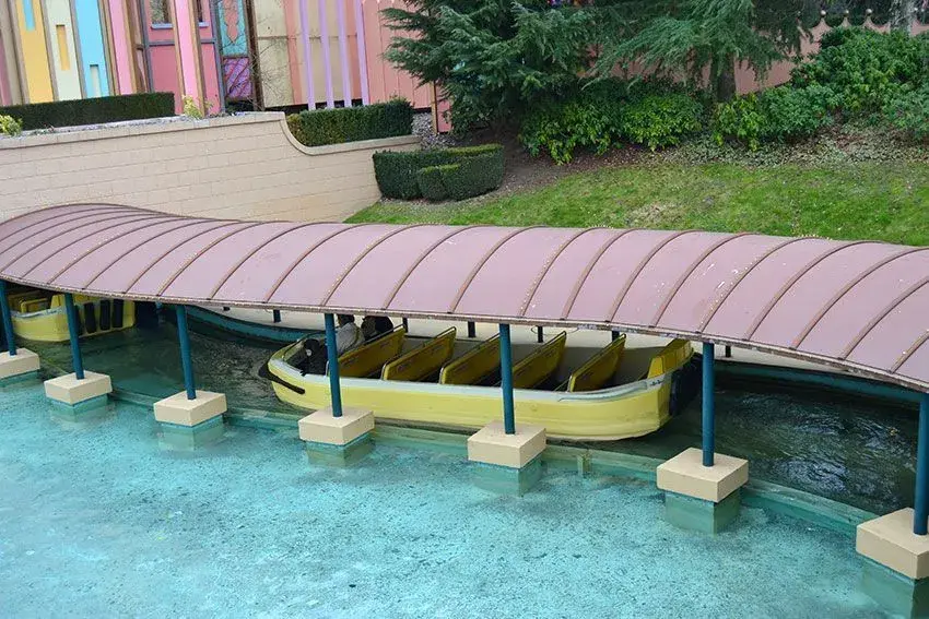 Pequeño bote pasando por debajo de un puente en la atracción It's a Small World