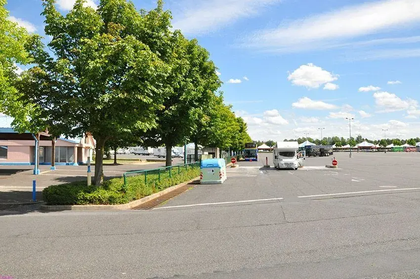 Vista del área de parking de autocaravanas rodeada de árboles
