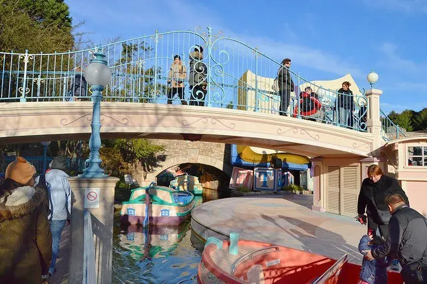 Visitantes cruzando el puente sobre el lago en Cuento de Hadas - Puente pintoresco de la atracción