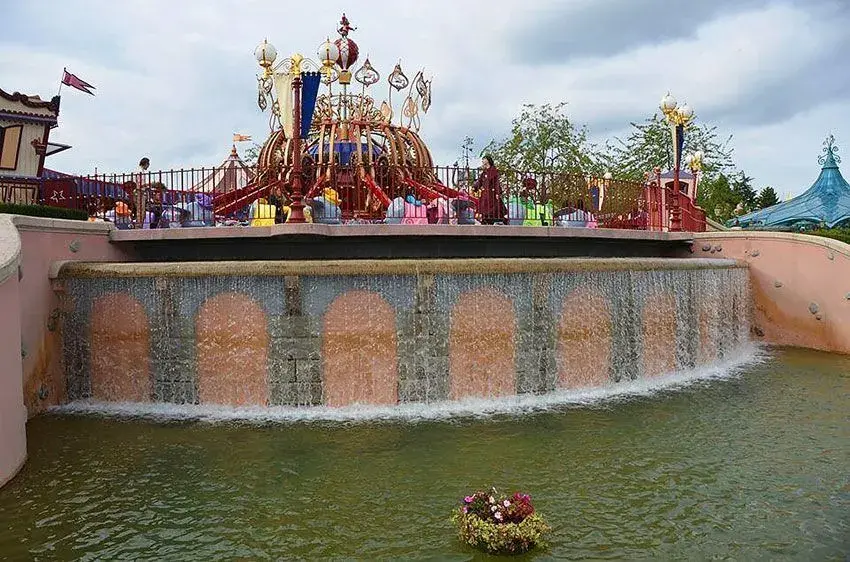Vista del lago con la atracción Dumbo Volador al fondo en Disneyland París