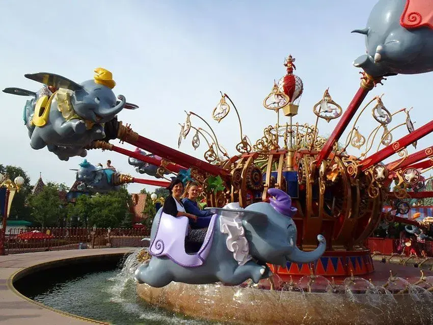 Visitantes disfrutando de la atracción Dumbo Volador en pleno vuelo