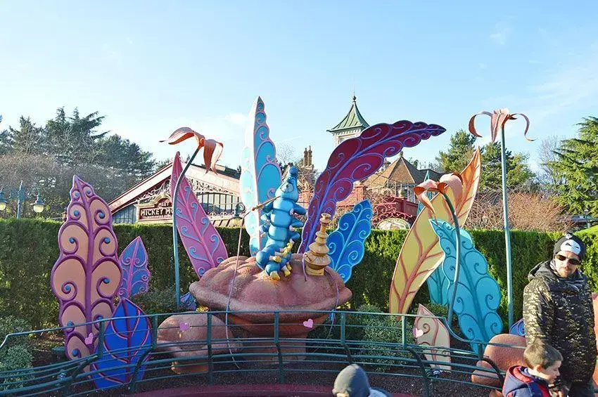 Visitante con niño y vista cercana de las decoraciones temáticas del Laberinto Alicia