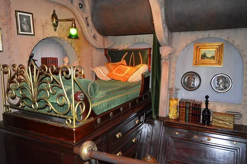 Habitación antigua en el Nautilus, con una cama sobre una cómoda de madera, decoración clásica