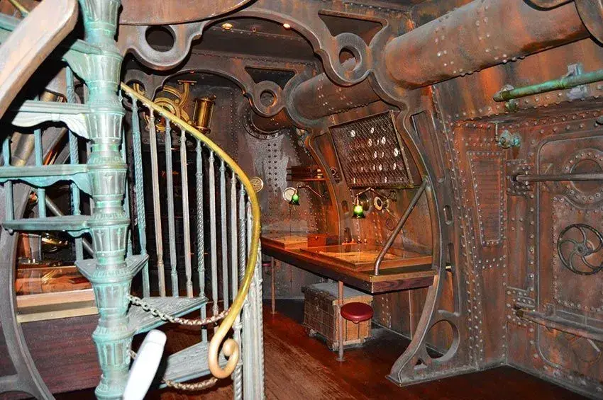 Mesa antigua con lámparas en la atracción Nautilus, ambientación retro