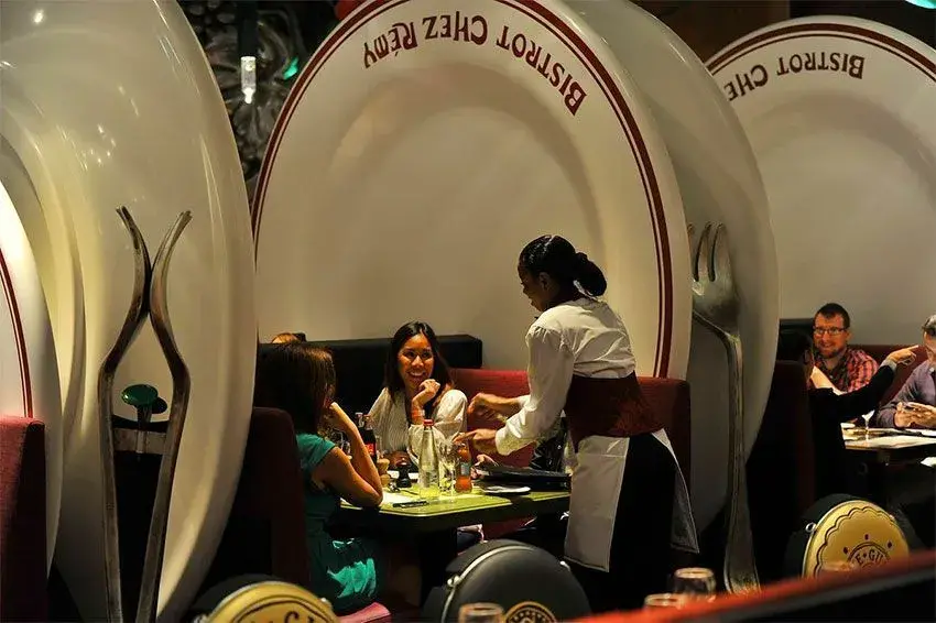 Interior del restaurante Le Bistrot Chez Rémy con una familia esperando a ser atendida
