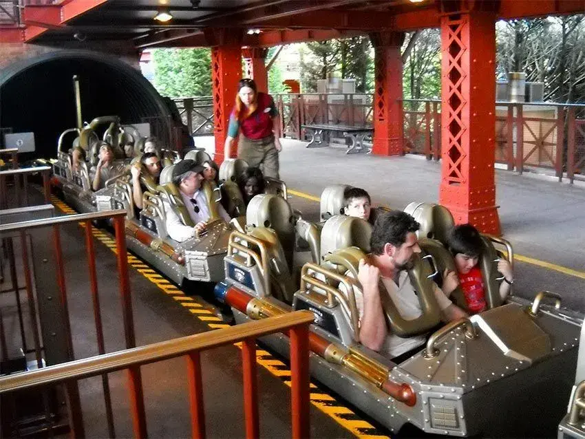Personas preparándose y asegurándose antes de iniciar la aventura en Space Mountain
                        