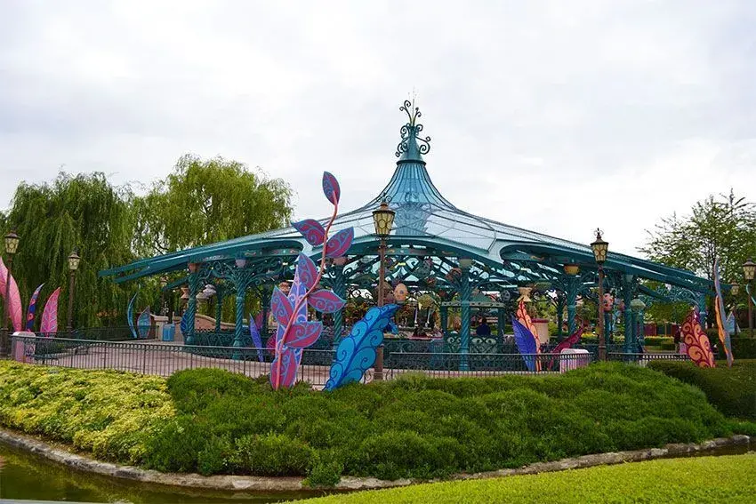 Decoración temática de la atracción Tazas Locas, visible desde el exterior, con colores vibrantes y elementos divertidos.