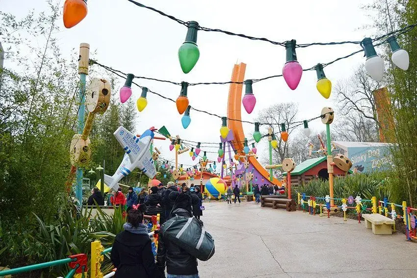 Imagen de la calle de Toy Story Playland, atracción con decoración temática y visitantes explorando